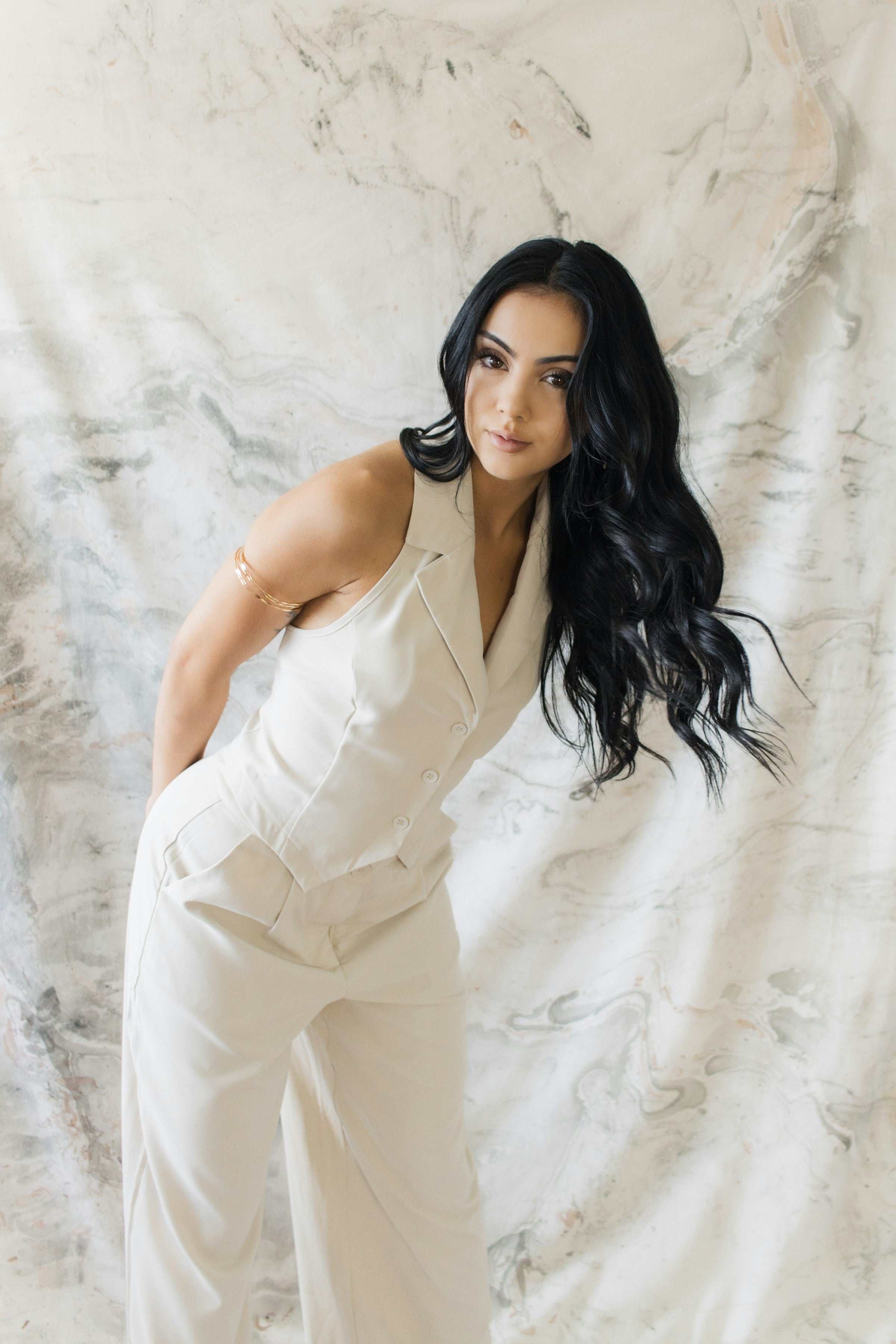 Woman wearing an ivory tailored sleeveless designer jumpsuit