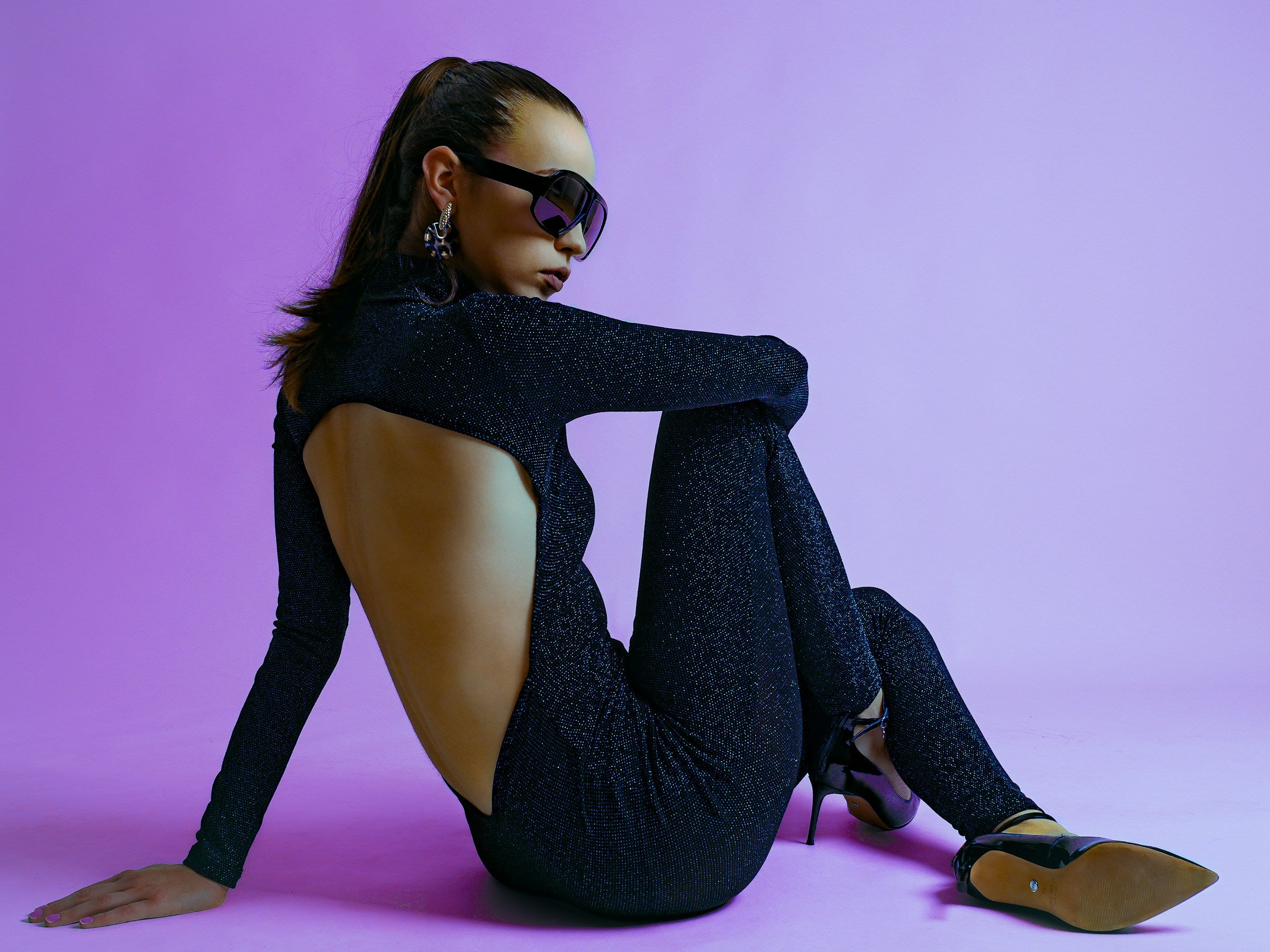 Woman wearing a sparkling black open-back designer evening jumpsuit