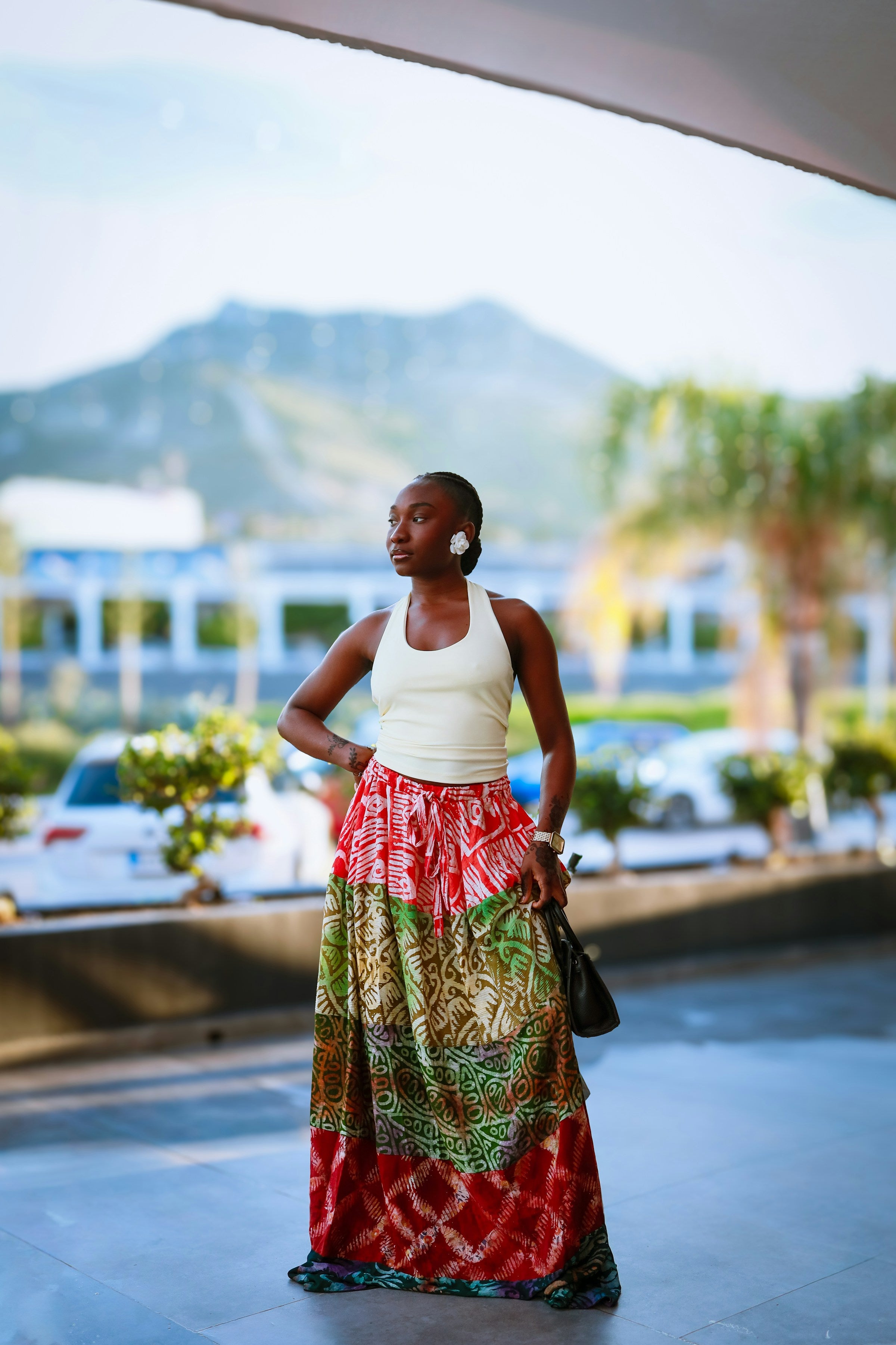 Woman wearing a white top with a colorful printed designer maxi skirt